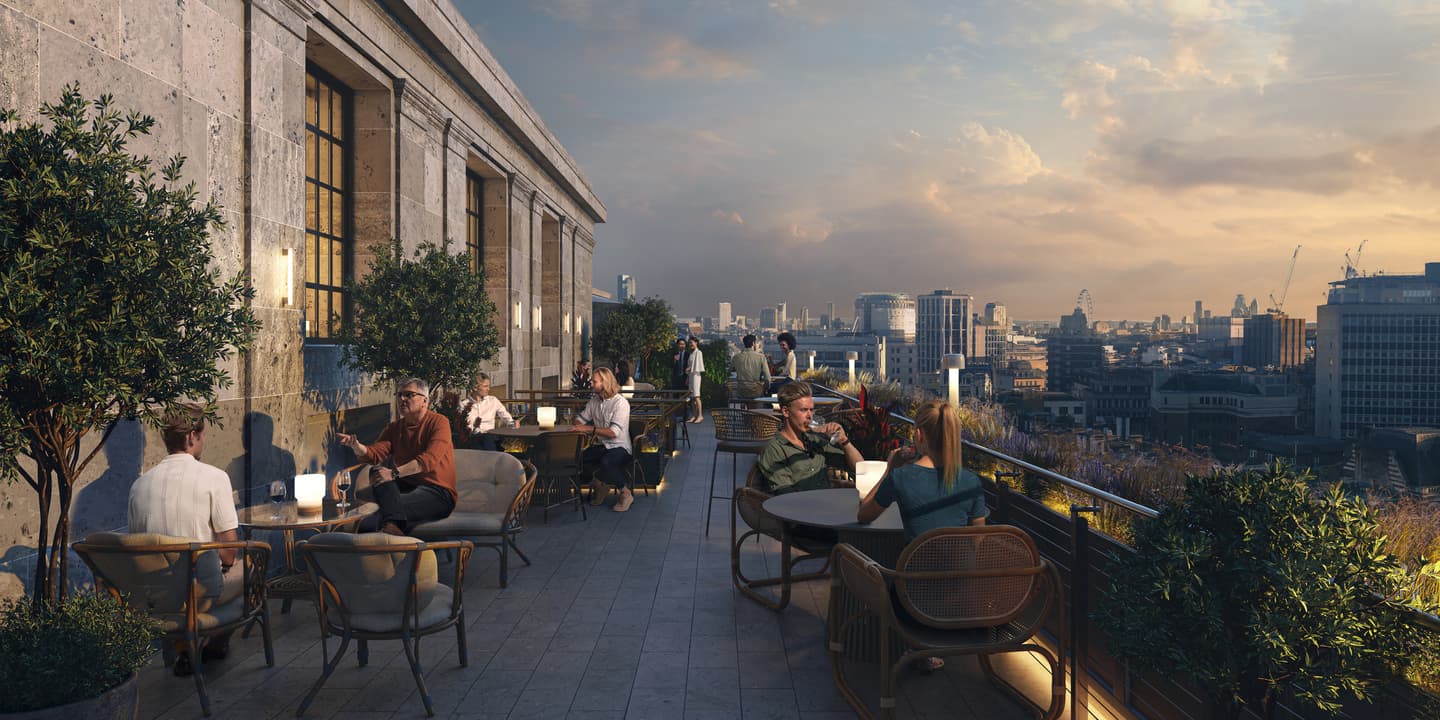 People sit at tables on a rooftop terrace with city views at sunset, surrounded by plants and enjoying drinks and conversation.