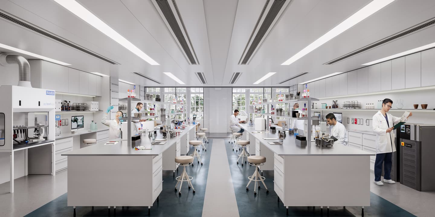 Spacious modern laboratory with several people in lab coats working at benches, surrounded by scientific equipment and shelves of supplies.