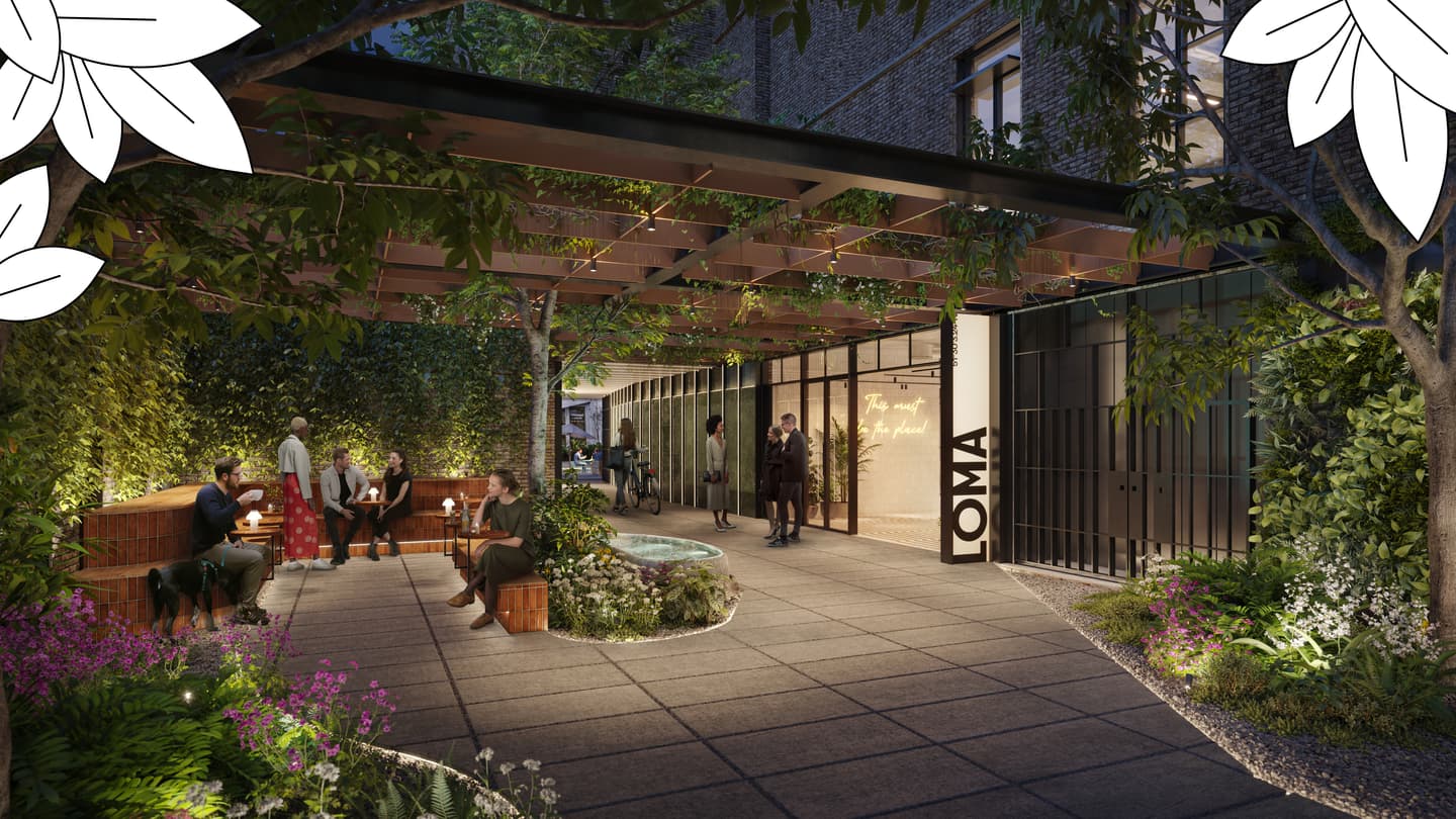 People sit and stand in a modern outdoor courtyard with greenery, benches, a small fountain, and a sign reading “OMA” on a wall near glass doors.